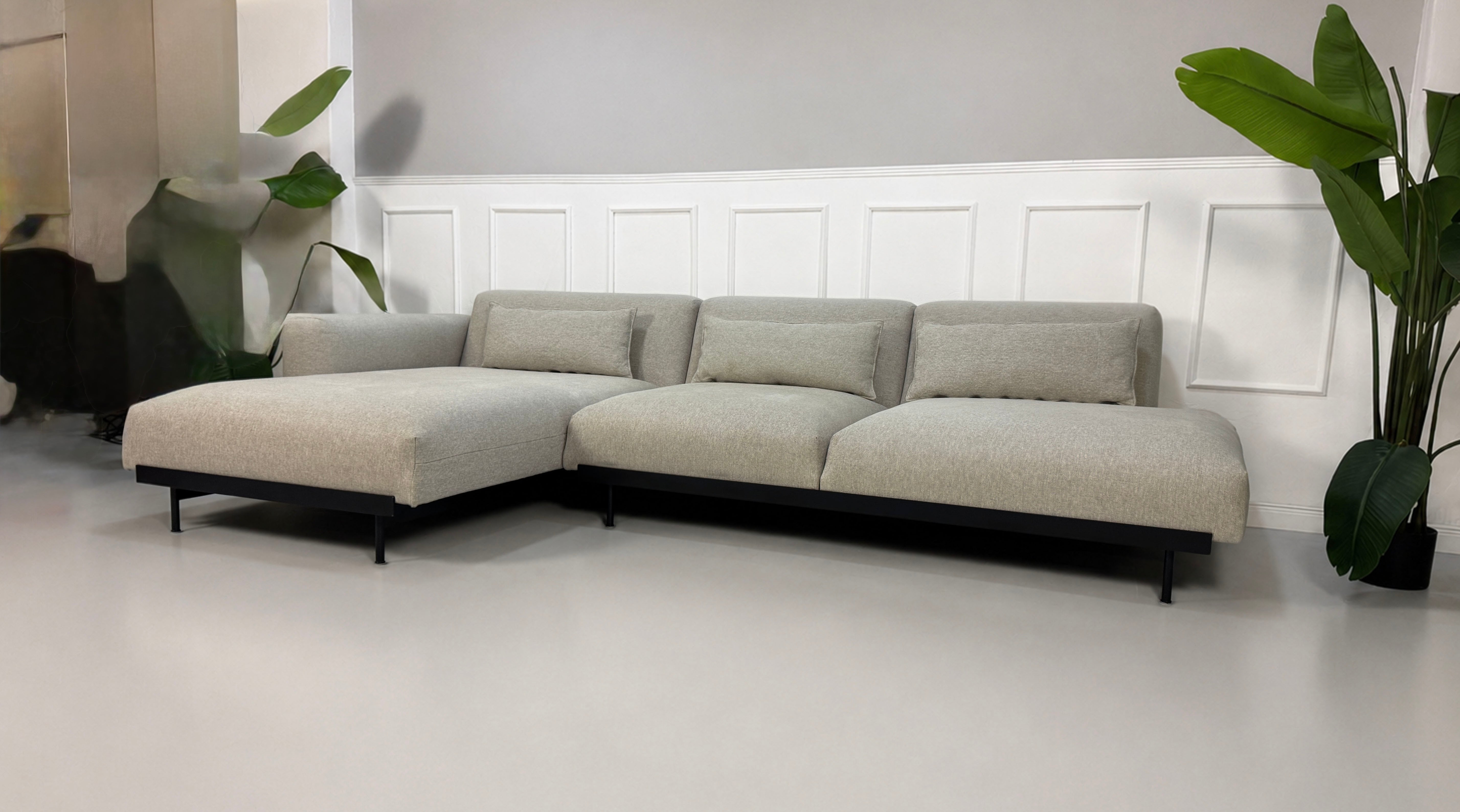 Gebrauchtes grau beiges Muuto In Situ Designer Stoff Sofa vor einer Wand, stilvoll und modern eingerichtet.