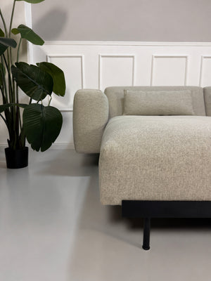 Gebrauchtes grau beiges Muuto In Situ Designer Stoff Sofa vor einer Wand, stilvoll und modern eingerichtet.