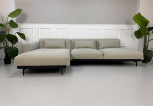 Gebrauchtes grau beiges Muuto In Situ Designer Stoff Sofa vor einer Wand, stilvoll und modern eingerichtet.