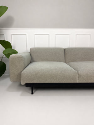 Gebrauchtes graues Muuto Situ Designer Stoff Sofa vor einer Wand, stilvoll und modern eingerichtet.