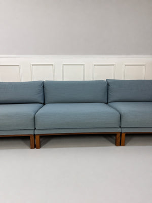 Gebrauchtes blaues Bolia Cosy Designer Stoff Sofa vor einer Wand, stilvoll und modern eingerichtet.