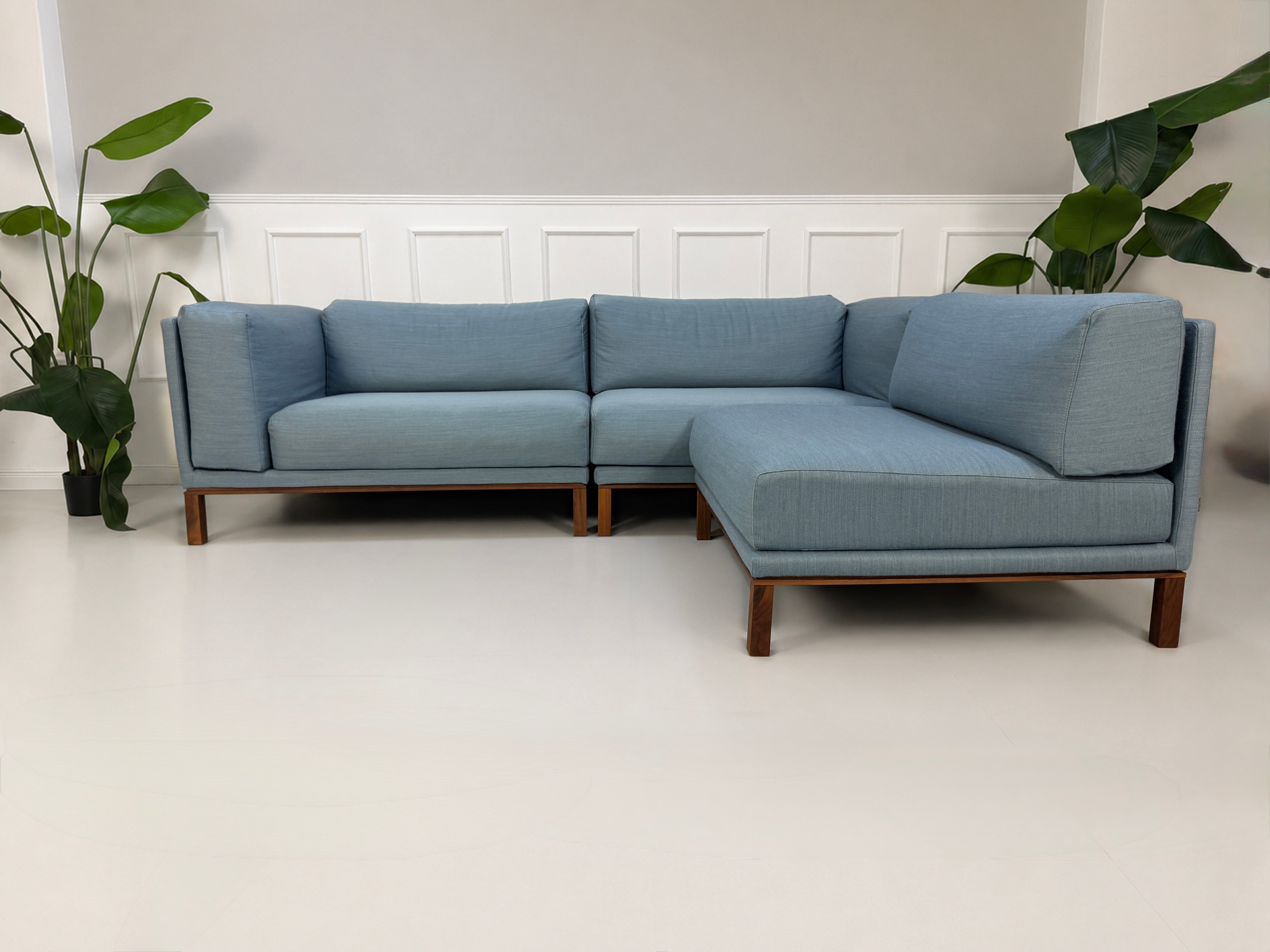 Gebrauchtes blaues Bolia Cosy Designer Stoff Sofa vor einer Wand, stilvoll und modern eingerichtet.