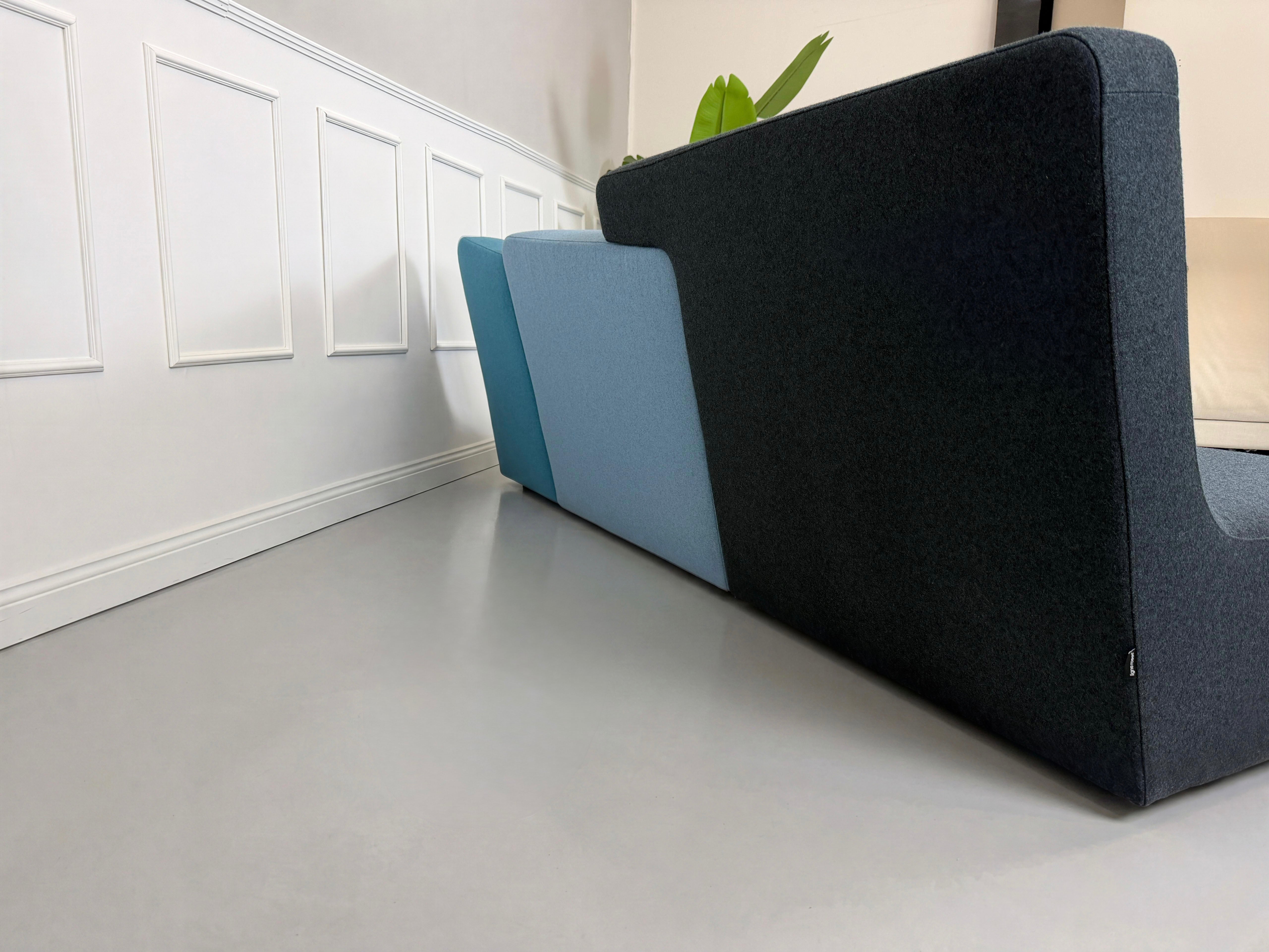 Gebrauchtes blaues Ligne Roset Confluences Designer Stoff Sofa vor einer Wand, stilvoll und modern eingerichtet.