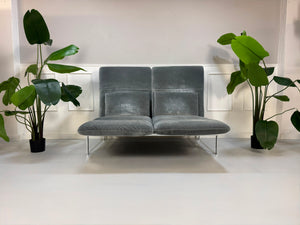 Gebrauchtes graues Brühl Roro medium Designer Stoff Sofa vor einer Wand, stilvoll und modern eingerichtet.