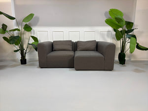 Gebrauchtes graues HAY Mags Designer Stoff Sofa vor einer Wand, stilvoll und modern eingerichtet.