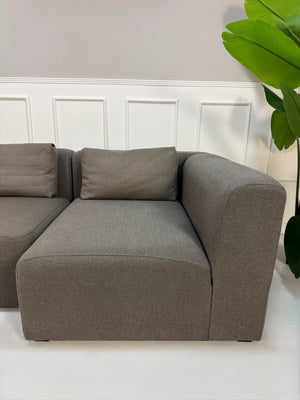 Gebrauchtes graues HAY Mags Designer Stoff Sofa vor einer Wand, stilvoll und modern eingerichtet.