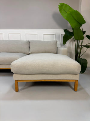 Gebrauchtes beiges Bolia North Designer Stoff Sofa vor einer Wand, stilvoll und modern eingerichtet.