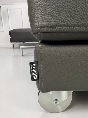 Ausstellungsstück Brühl Four Two Designer Leder Sofa vor einer Wand, stilvoll und modern eingerichtet.