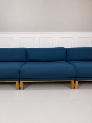 Gebrauchtes blaues Bolia Cosy Designer Stoff Sofa vor einer Wand, stilvoll und modern eingerichtet.
