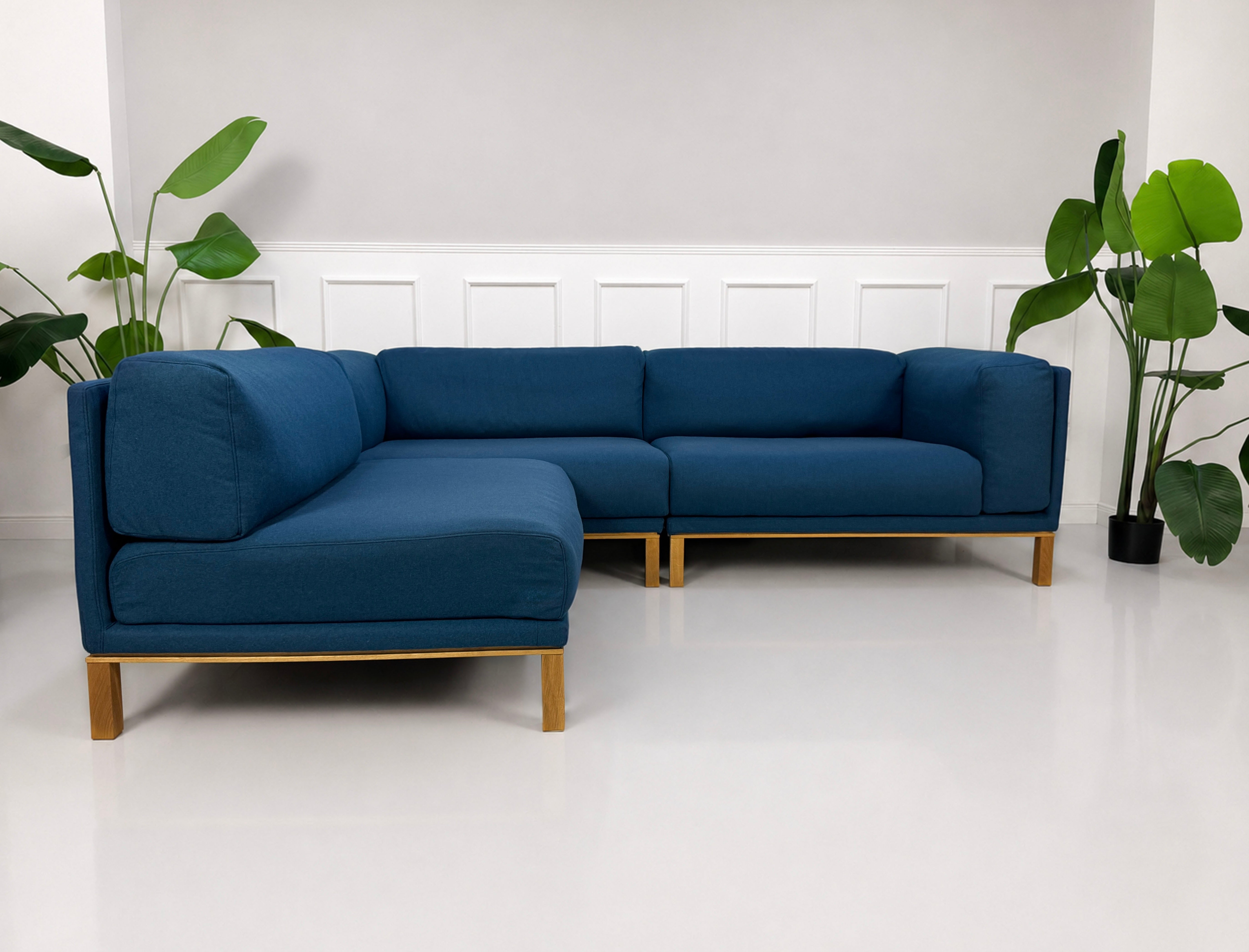 Gebrauchtes blaues Bolia Cosy Designer Stoff Sofa vor einer Wand, stilvoll und modern eingerichtet.