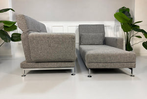 Gebrauchtes graues Brühl Moule Designer Stoff Sofa vor einer Wand, stilvoll und modern eingerichtet.