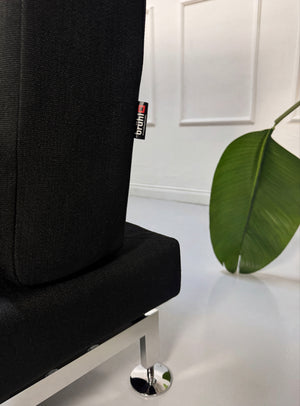 Gebrauchtes schwarzes Brühl Moule Designer Stoff Sofa vor einer Wand, stilvoll und modern eingerichtet.