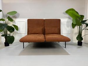 Gebrauchtes braunes Brühl Roro Designer Leder Taron Sofa vor einer Wand, stilvoll und modern eingerichtet.
