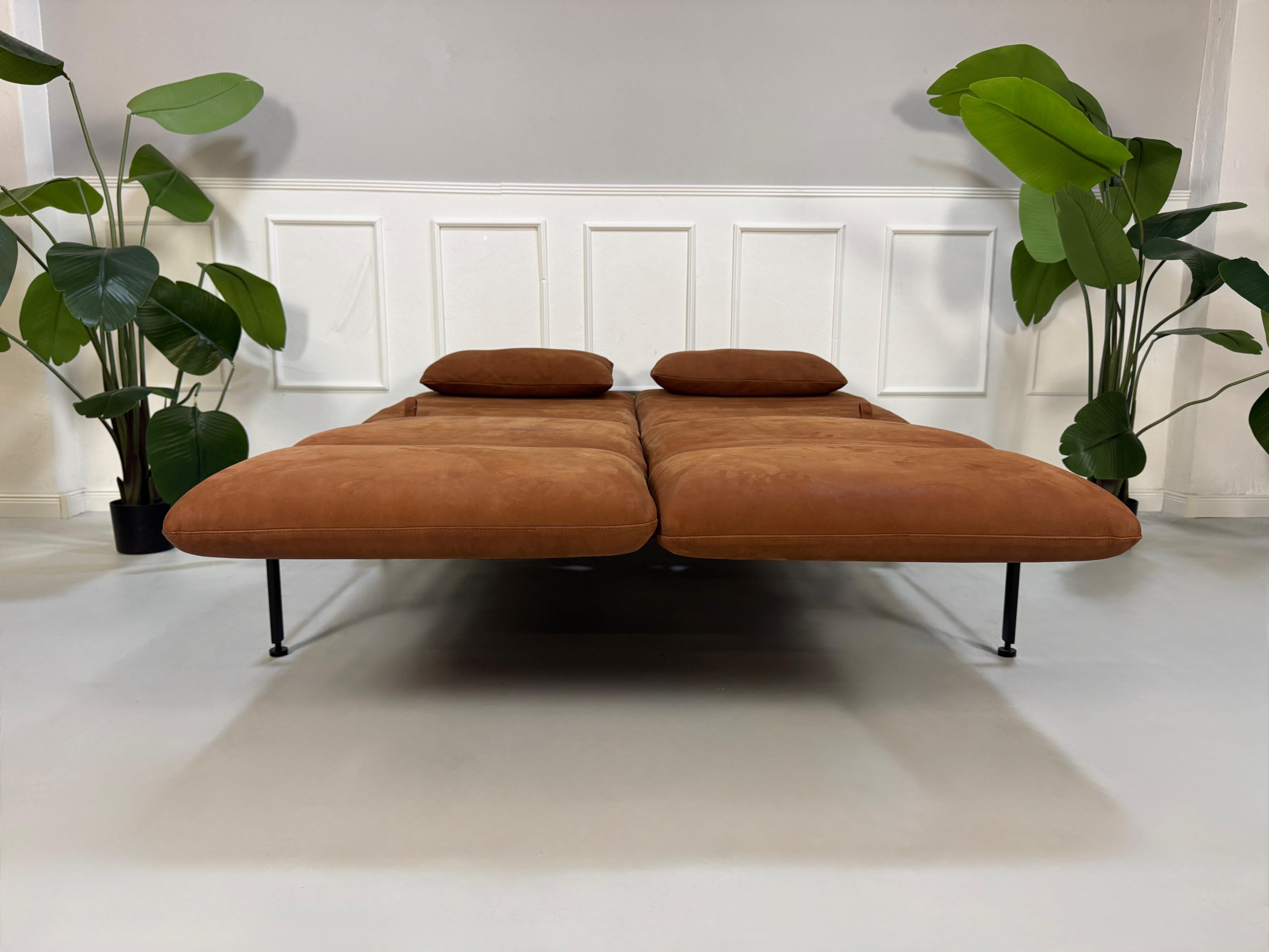 Gebrauchtes braunes Brühl Roro Designer Leder Taron Sofa vor einer Wand, stilvoll und modern eingerichtet.