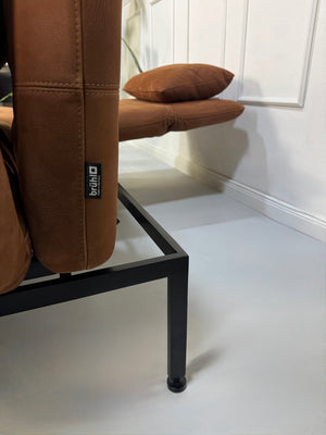 Gebrauchtes braunes Brühl Roro Designer Leder Taron Sofa vor einer Wand, stilvoll und modern eingerichtet.