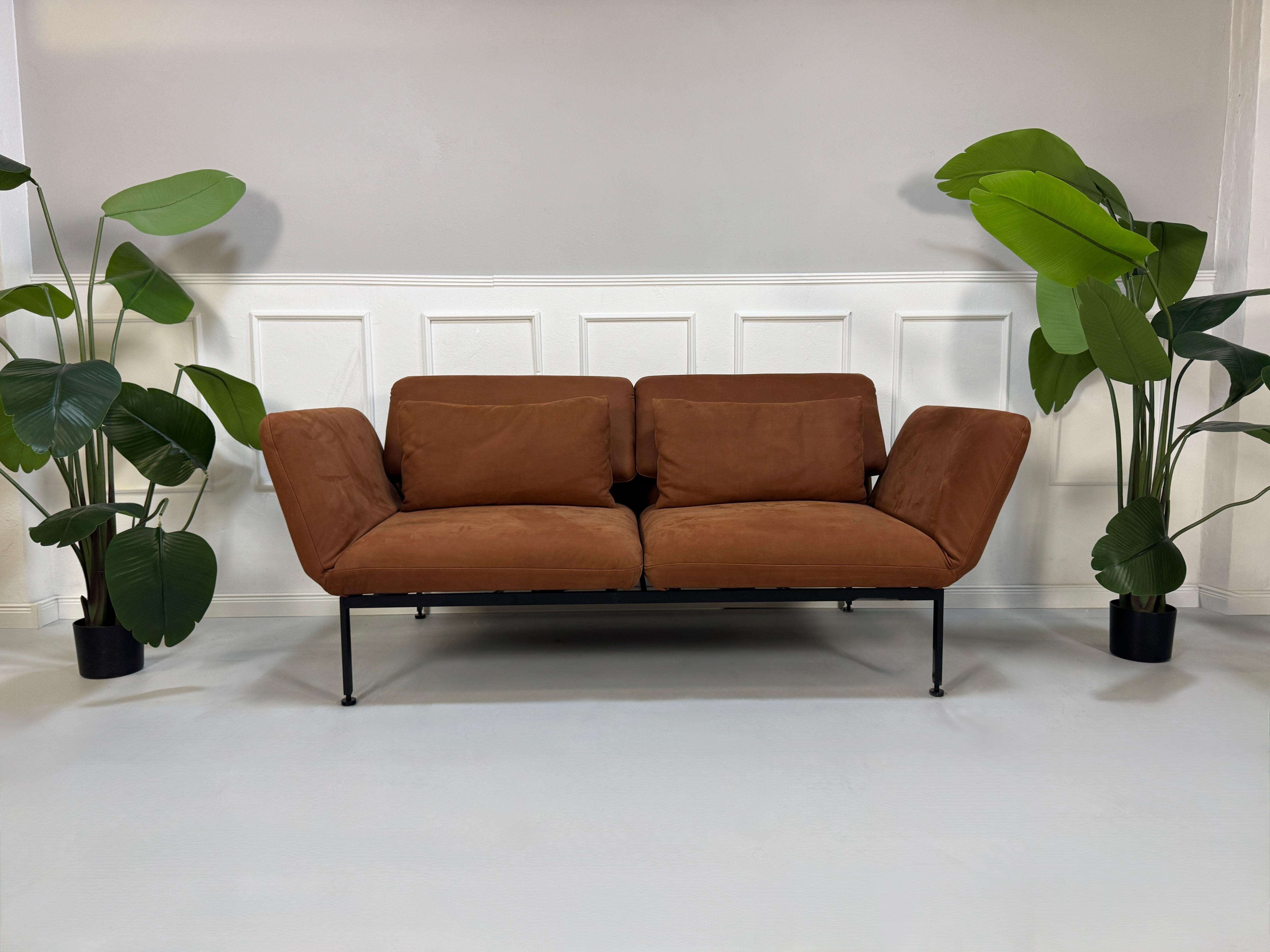 Gebrauchtes braunes Brühl Roro Designer Leder Taron Sofa vor einer Wand, stilvoll und modern eingerichtet.