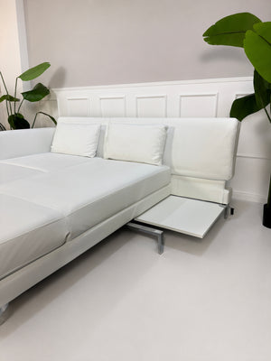 Ausstellungsstück weißes Brühl FourTwo Designer Leder Sofa vor einer Wand, stilvoll und modern eingerichtet.