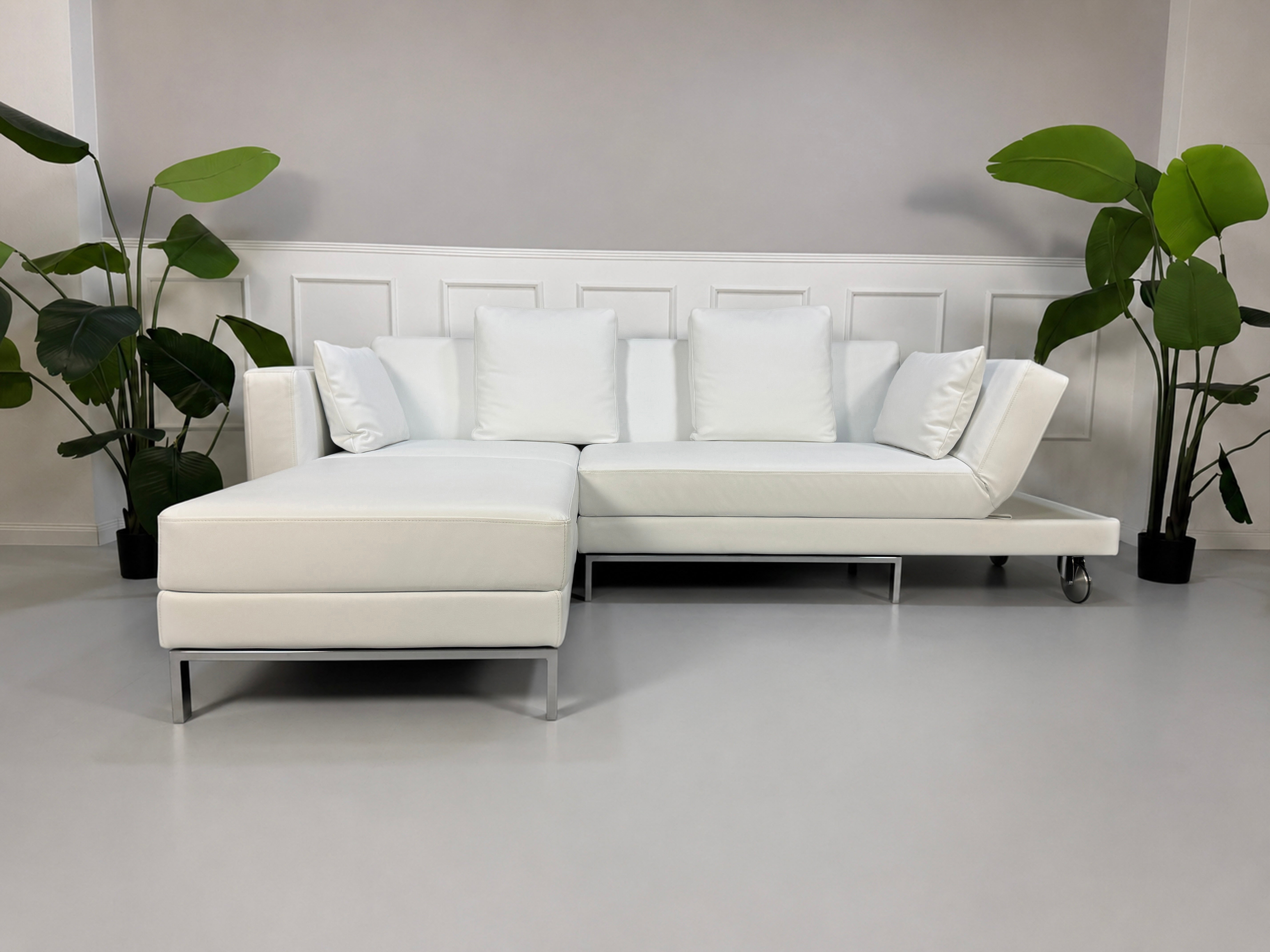 Ausstellungsstück weißes Brühl FourTwo Designer Leder Sofa vor einer Wand, stilvoll und modern eingerichtet.