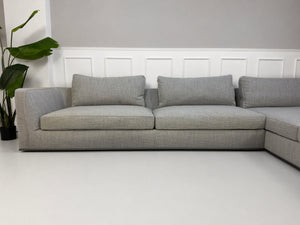 Gebrauchtes graues B&B Italia Richard Designer Stoff Sofa vor einer Wand, stilvoll und modern eingerichtet.
