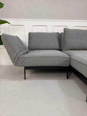 Gebrauchtes graues Rolf Benz Mera Designer Stoff Sofa vor einer Wand, stilvoll und modern eingerichtet.