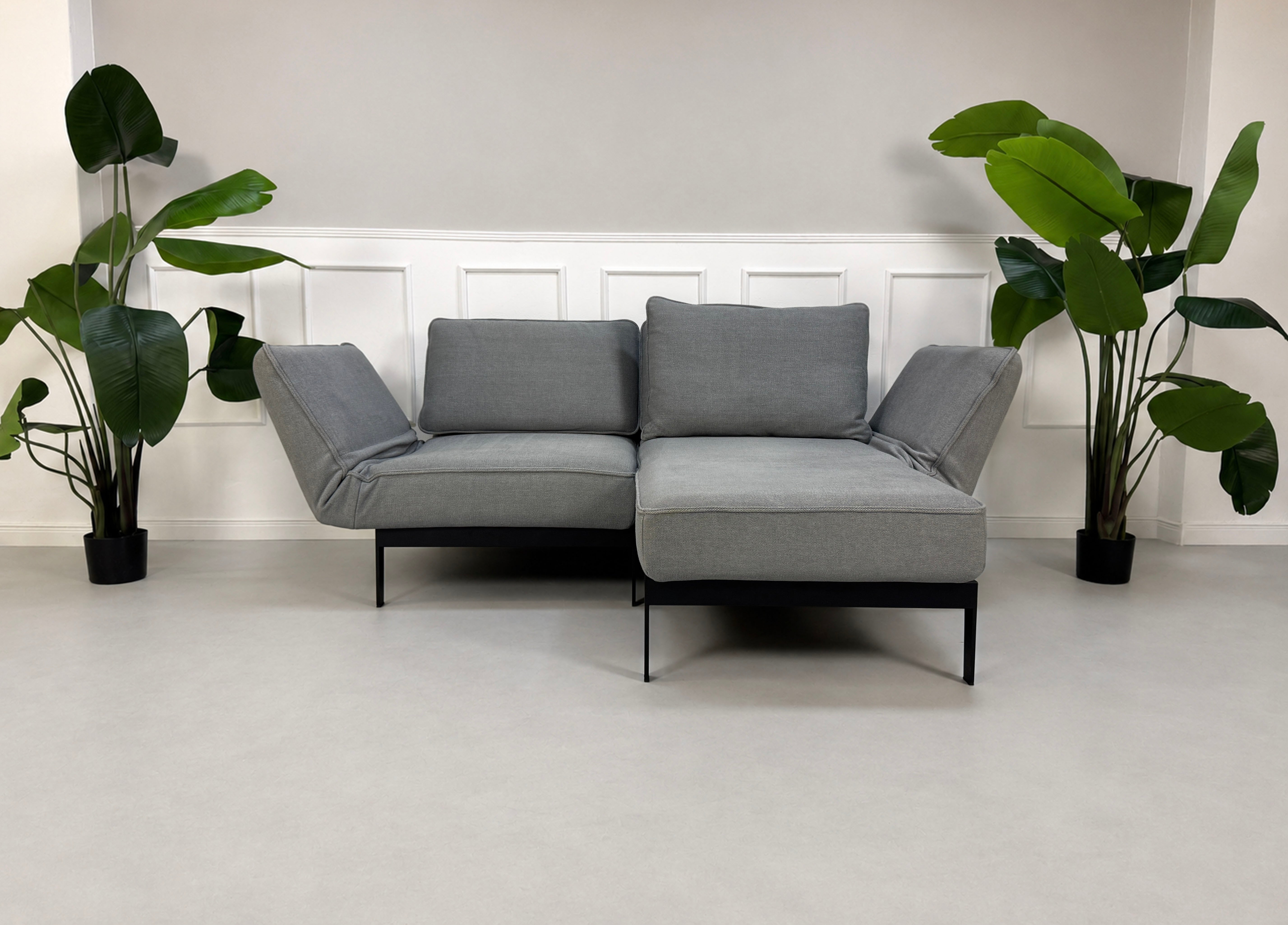 Gebrauchtes graues Rolf Benz Mera Designer Stoff Sofa vor einer Wand, stilvoll und modern eingerichtet.