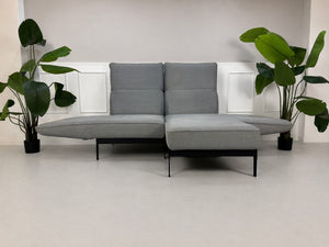 Gebrauchtes graues Rolf Benz Mera Designer Stoff Sofa vor einer Wand, stilvoll und modern eingerichtet.