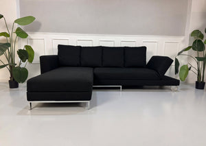 Gebrauchtes schwarzes Brühl Fourtwo Designer Stoff Sofa vor einer Wand, stilvoll und modern eingerichtet.