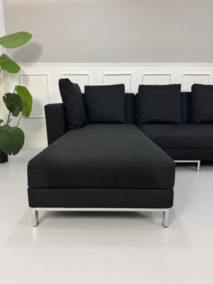 Gebrauchtes schwarzes Brühl Fourtwo Designer Stoff Sofa vor einer Wand, stilvoll und modern eingerichtet.