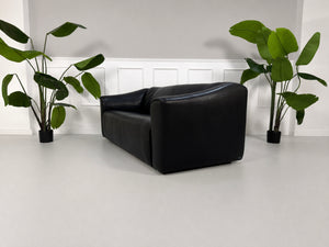 Gebrauchtes schwarzes De Sede DS47 Designer Leder Sofa vor einer Wand, stilvoll und modern eingerichtet.