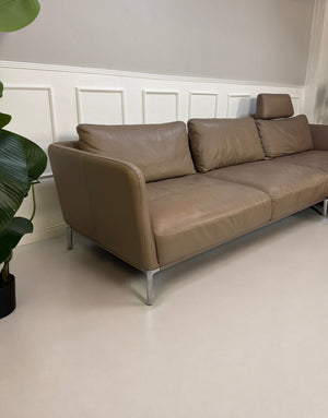 Gebrauchtes Braun Grau Rolf Benz Scala Designer Leder Sofa vor einer Wand, stilvoll und modern eingerichtet.