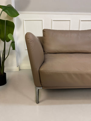 Gebrauchtes Braun Grau Rolf Benz Scala Designer Leder Sofa vor einer Wand, stilvoll und modern eingerichtet.