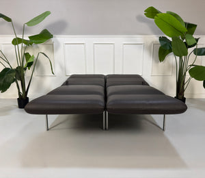 Gebrauchte braune Brühl Roro Designer Leder Sofas vor einer Wand, stilvoll und modern eingerichtet.