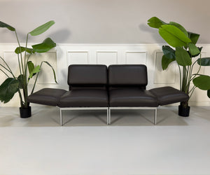Gebrauchte braune Brühl Roro Designer Leder Sofas vor einer Wand, stilvoll und modern eingerichtet.