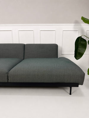 Gebrauchtes graues Muuto In Situ Designer Stoff Sofa vor einer Wand, stilvoll und modern eingerichtet.