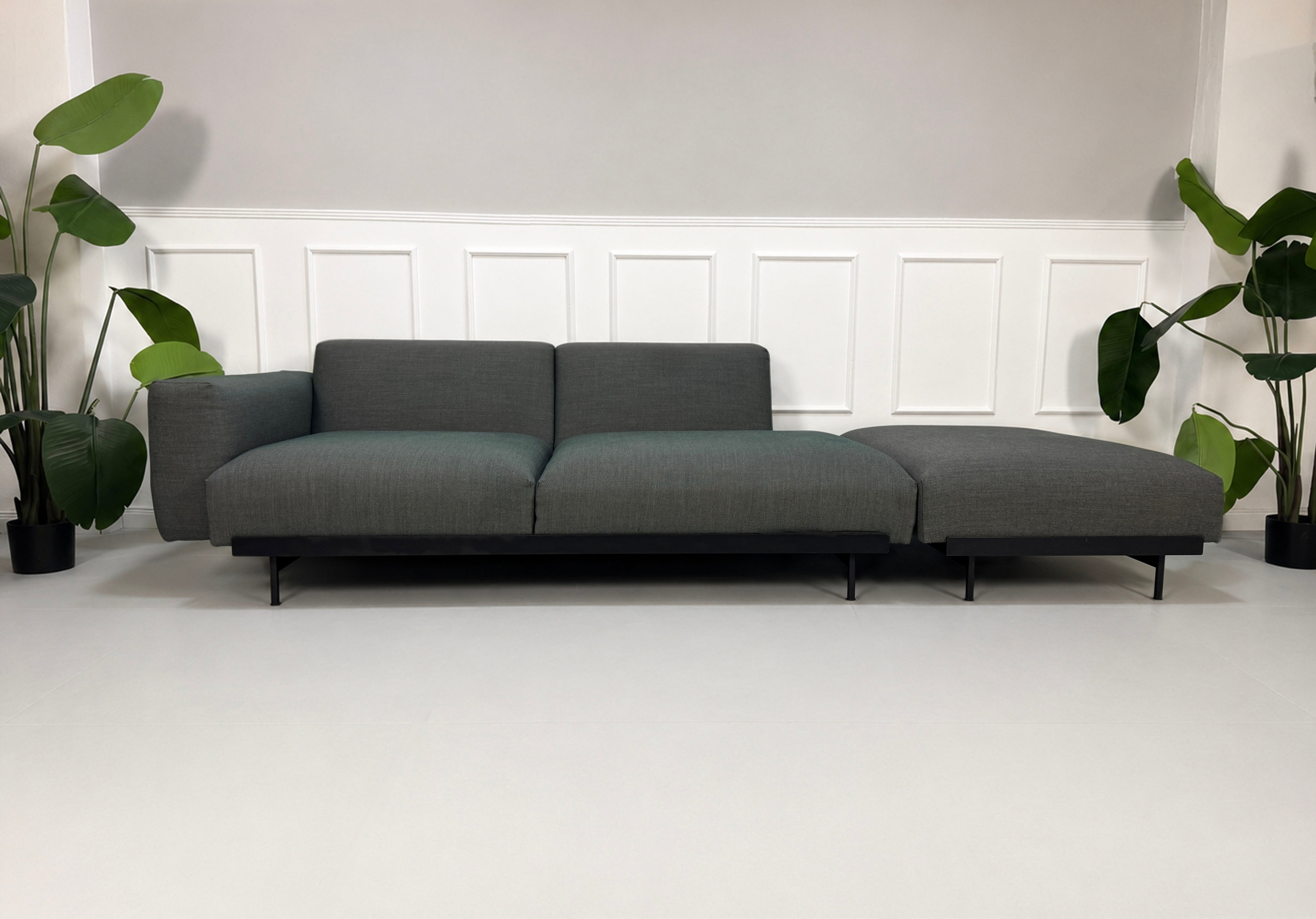 Gebrauchtes graues Muuto In Situ Designer Stoff Sofa vor einer Wand, stilvoll und modern eingerichtet.