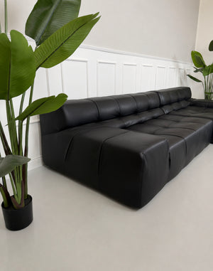Gebrauchtes schwarzes B&B Italia Tufty Time Designer Leder Sofa vor einer Wand, stilvoll und modern eingerichtet.
