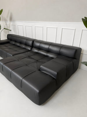 Gebrauchtes schwarzes B&B Italia Tufty Time Designer Leder Sofa vor einer Wand, stilvoll und modern eingerichtet.