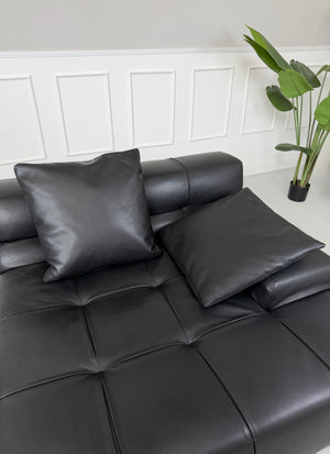 Gebrauchtes schwarzes B&B Italia Tufty Time Designer Leder Sofa vor einer Wand, stilvoll und modern eingerichtet.