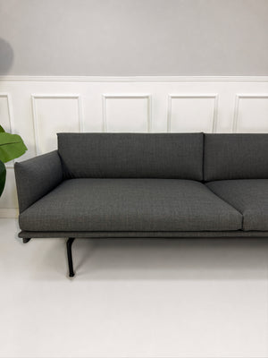 Gebrauchtes graues Muuto Outline Designer Stoff Sofa vor einer Wand, stilvoll und modern eingerichtet.