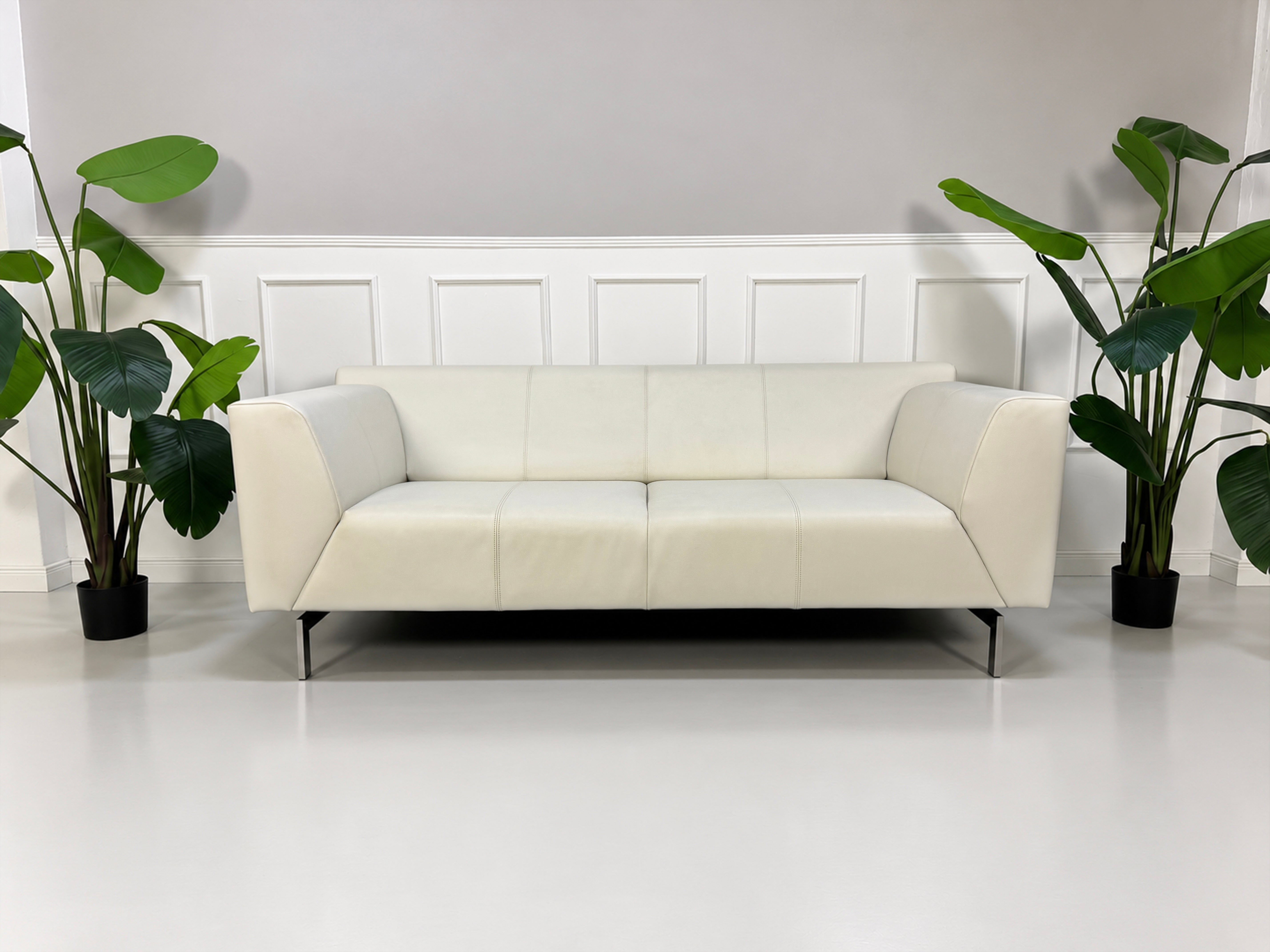 Gebrauchtes weißes Rolf Benz Linea 318 Designer Leder Sofa vor einer Wand, stilvoll und modern eingerichtet.