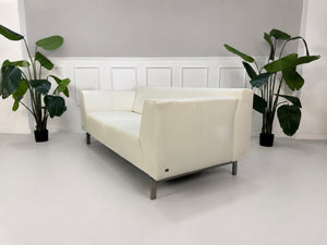 Gebrauchtes weißes Rolf Benz Linea 318 Designer Leder Sofa vor einer Wand, stilvoll und modern eingerichtet.