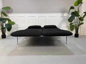 Gebrauchtes graues Brühl Roro Designer Stoff Sofa vor einer Wand, stilvoll und modern eingerichtet.