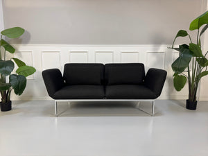 Gebrauchtes graues Brühl Roro Designer Stoff Sofa vor einer Wand, stilvoll und modern eingerichtet.