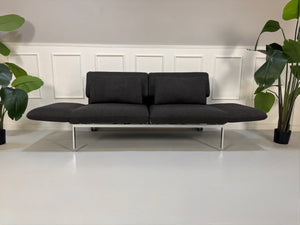 Gebrauchtes graues Brühl Roro Designer Stoff Sofa vor einer Wand, stilvoll und modern eingerichtet.