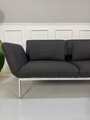 Gebrauchtes graues Brühl Roro Designer Stoff Sofa vor einer Wand, stilvoll und modern eingerichtet.