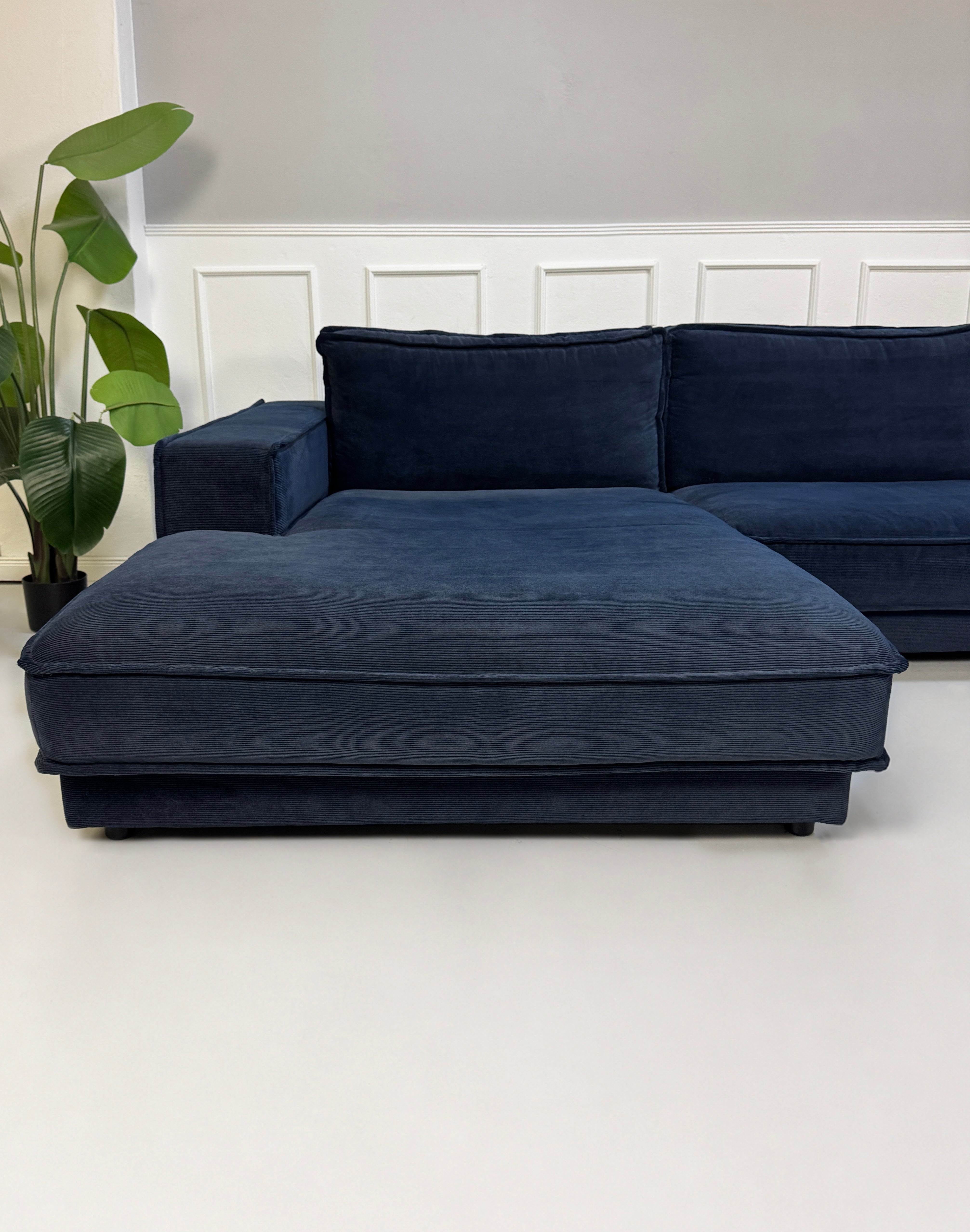 Gebrauchtes blaues Bolia Noora Designer Stoff Sofa vor einer Wand, stilvoll und modern eingerichtet.