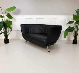 Gebrauchtes schwarzes De Sede DS 102 Designer Leder Sofa vor einer Wand, stilvoll und modern eingerichtet.