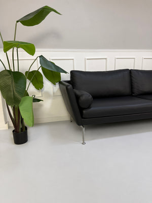 Gebrauchtes schwarzes Vitra Suita Designer Leder Sofa, Detailansicht von Armlehne und Nackenrolle.