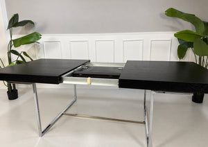 Gebrauchter grauer B&B Italia Athos Designer Chrom Tisch vor einer Wand, stilvoll und modern eingerichtet.