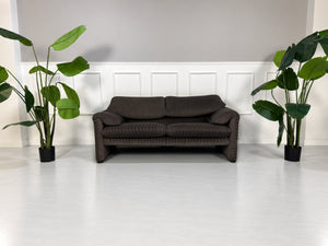 Gebrauchtes braun-schwarzes Cassina Maralunga Designer Stoff Sofa vor einer Wand, stilvoll und modern eingerichtet.